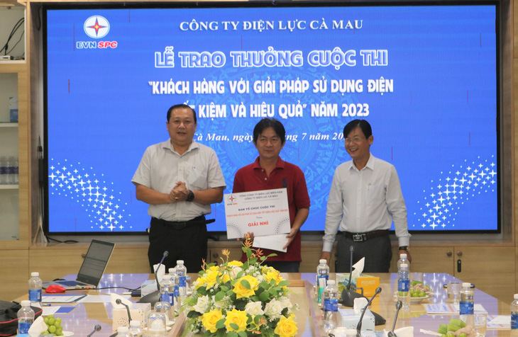 Đại diện chính quyền địa phương và Công ty Điện lực Cà Mau trao giải nhì cho khách hàng - Ảnh: Công ty cung cấp