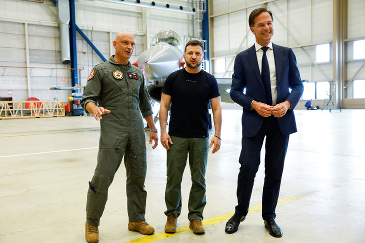 Tổng thống Ukraine Volodymyr Zelensky (giữa) và Thủ tướng Hà Lan Mark Rutte (phải) đứng gần một chiếc F-16 ở Eindhoven, Hà Lan, ngày 20-8 - Ảnh: REUTERS