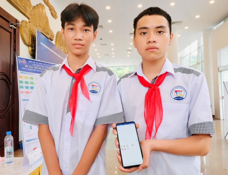 Nguyễn Hoàng Phú và Phùng Khôi Nguyên (từ trái qua) giới thiệu ứng dụng “The Deaf People” hỗ trợ giao tiếp với người khiếm thính, người già lãng tai - Ảnh: HÀ THANH