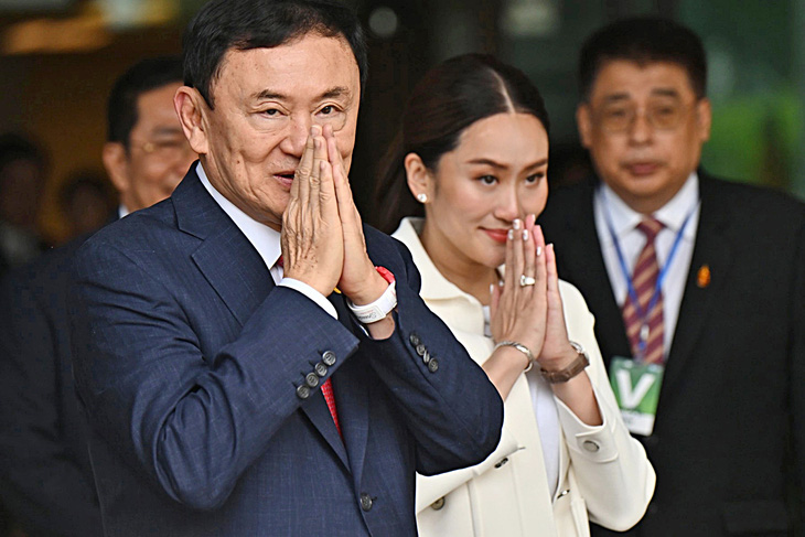 Ông Thaksin đáp chào người dân ở sân bay trước khi đi thẳng vào nhà tù - Ảnh: AFP