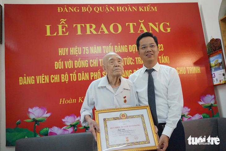 Ông Vũ Đăng Định - bí thư Quận ủy Hoàn Kiếm - trao huy hiệu 75 năm tuổi Đảng cho nhà báo Thái Duy - Ảnh: T.ĐIỂU