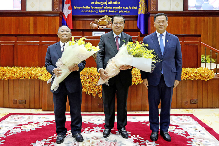 Tân Thủ tướng Hun Manet (phải) tặng hoa cho nguyên Thủ tướng Hun Sen (giữa) và nguyên Chủ tịch Quốc hội Campuchia Heng Samrin ngày 22-8 - Ảnh: AFP