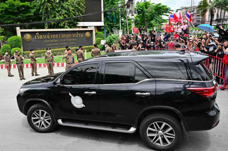 Những người ủng hộ ông Thaksin ở bên ngoài khi xe cảnh sát chở cựu thủ tướng Thái Lan đến nhà tù trung tâm Klong Prem ở Bangkok hôm 22-8 - Ảnh: AFP