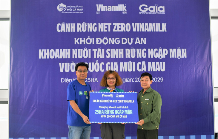 Ông Lê Hoàng Minh (trái), đại diện Vinamilk, và bà Đỗ Thị Thanh Huyền, đại diện Gaia, trao tượng trưng bảng 25 hecta rừng ngập mặn thuộc dự án &quot;Cánh rừng Net Zero Vinamilk&quot; cho đại diện Vườn quốc gia Mũi Cà Mau - Ảnh: NGUYỄN HIỆU