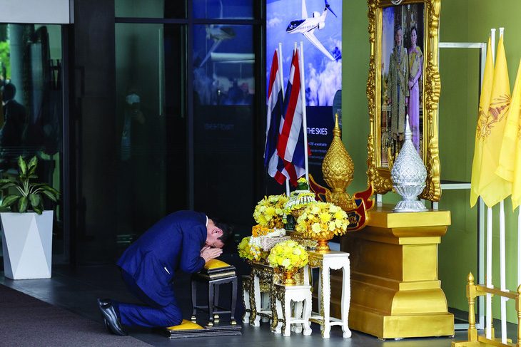 Ông Thaksin quỳ trước hình ảnh hoàng gia Thái. Ảnh: Bloomberg