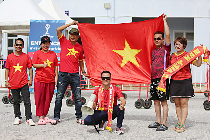 Anh Trần Duy Đạt (ngồi) cùng nhóm CĐV Thái Lan và Việt Nam trước giờ cổ vũ U23 Việt Nam thi đấu bán kết - Ảnh: HOÀNG TÙNG