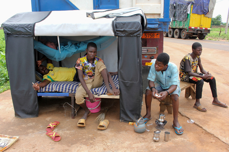Các tài xế xe tải chở lương thực và hàng hóa cứu trợ phải dựng lán ngủ tạm tại vùng biên giới Niger - Benin do lệnh cấm vận nên không vào được Niger trong khi hàng triệu người dân Niger đang chờ giúp đỡ - Ảnh: REUTERS