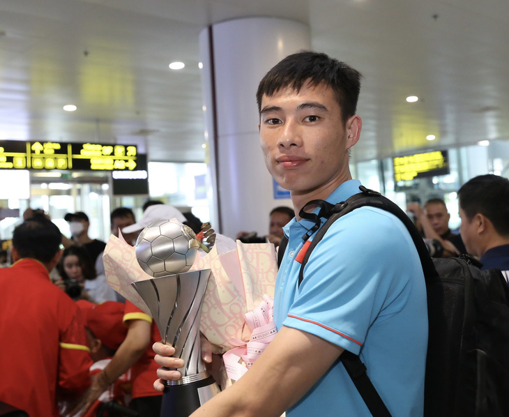 Thủ môn và đội trưởng Quan Văn Chuẩn với chiếc cúp vô địch U23 Đông Nam Á tại sân bay Nội Bài 