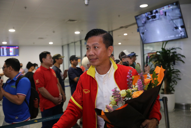 Ông Hoàng Anh Tuấn với bó hoa nhận được từ tay tổng thư ký VFF Dương Nghiệp Khôi 