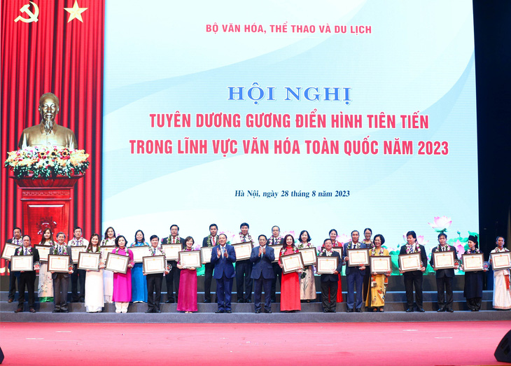 Thủ tướng Phạm Minh Chính và Bộ trưởng Bộ Văn hóa, Thể thao và Du lịch Nguyễn Văn Hùng trao bằng khen cho các điển hình tiên tiến trong lĩnh vực văn hóa - Ảnh: TRẦN HUẤN