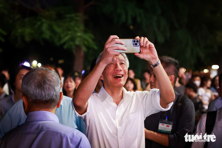 Thủ tướng Lý Hiển Long chụp ảnh khi đi dạo tại Hồ Gươm vào tối 27-8 - Ảnh: NGUYỄN KHÁNH