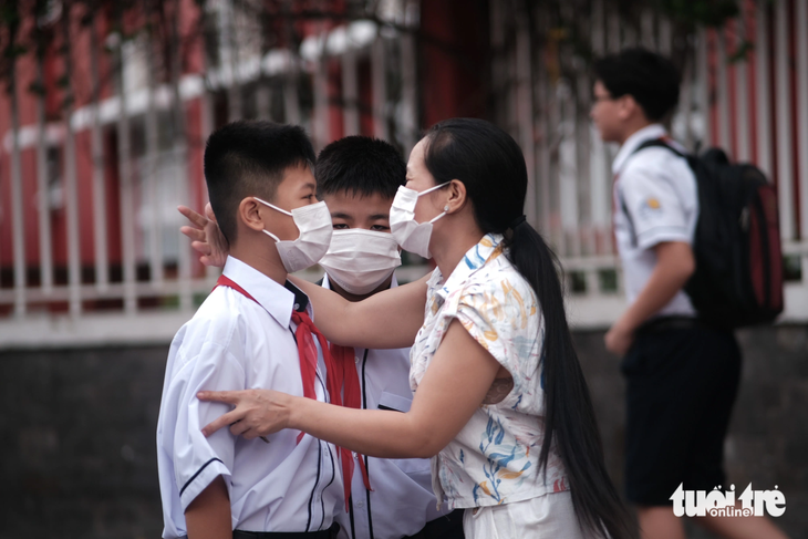 Chị Ngọc Anh ôm hôn động viên hai con bước năm học mới - Ảnh: NGỌC PHƯỢNG