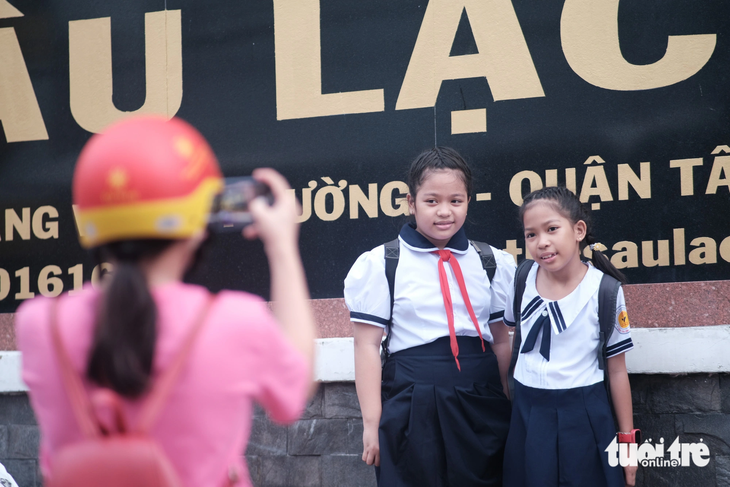 Chị Diễm Phú (quận Tân Bình) chụp hình lưu lại khoảnh khắc hai cô con gái vào năm học mới - Ảnh: NGỌC PHƯỢNG