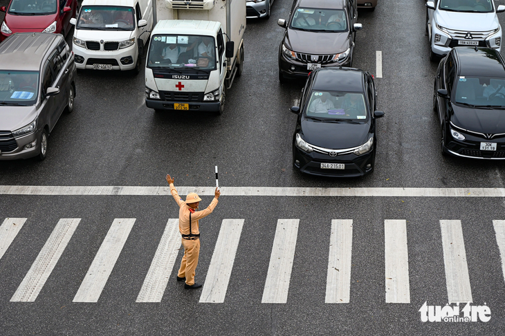 Dù đã qua nhịp đèn xanh, cảnh sát giao thông thường xuyên ngăn xe cộ đi lên cầu để giảm tải - Ảnh: HỒNG QUANG