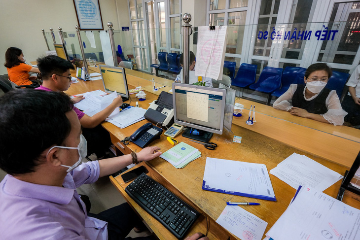 Cán bộ xử lý hồ sơ bảo hiểm xã hội tại Bảo hiểm xã hội quận Hoàng Mai - Ảnh: NAM TRẦN
