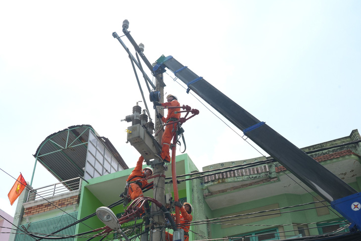 Nhân viên Công ty Điện lực Phú Thọ, TP.HCM kiểm tra và bảo trì mạng lưới điện trung thế trên đường Bình Thới, quận 11, nhằm đảm bảo nguồn điện sinh hoạt ổn định cho người dân - Ảnh: HỮU HẠNH