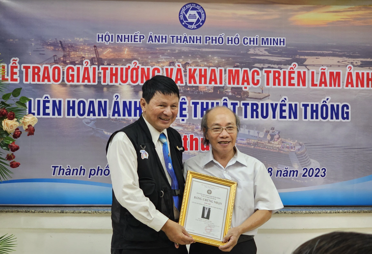 Ông Đoàn Hoài Trung (bên trái) - chủ tịch Hội Nhiếp ảnh TP.HCM - trao giải cho tác giả đoạt giải chiều 29-8 - Ảnh: BTC