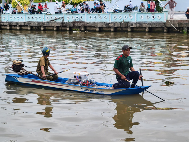 Lực lượng chức năng của thị trấn Phước Long tìm kiếm cá sấu trên sông 30 Tháng 4 vào chiều 29-8 - Ảnh: CHÍ QUỐC 