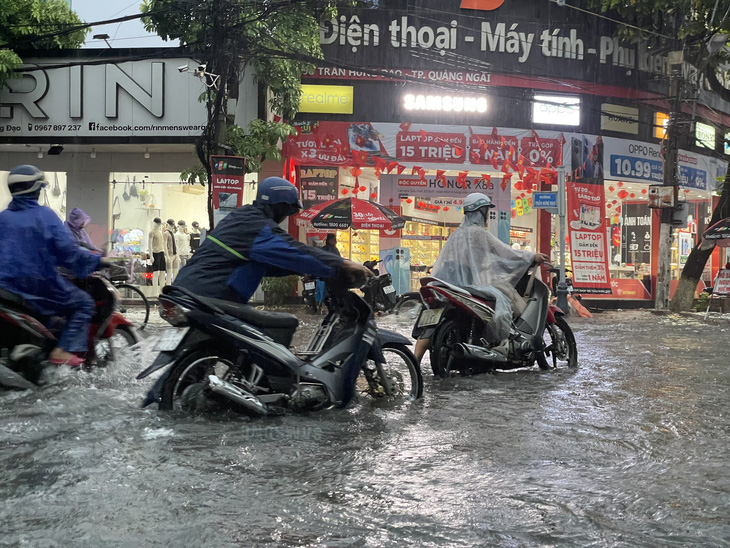 Nhiều xe máy dắt bộ vì ngập nước tại thành phố Quảng Ngãi - Ảnh: TR.M