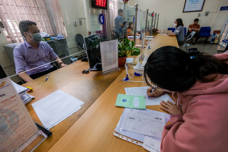 Người dân làm thủ tục liên quan đến lương hưu, trợ cấp, bảo hiểm xã hội tại Bảo hiểm xã hội quận Hoàng Mai, Hà Nội - Ảnh: NAM TRẦN