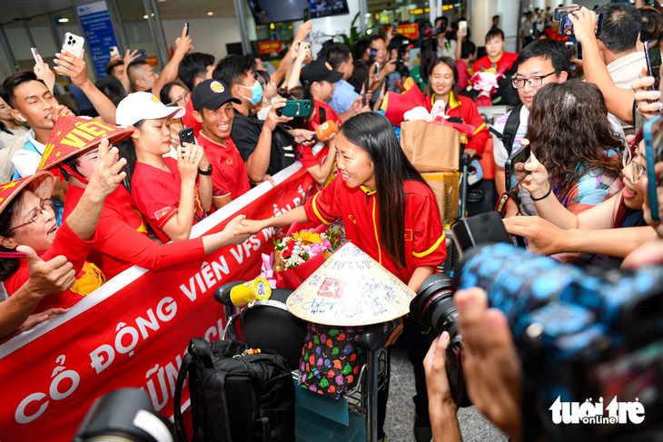 Huỳnh Như và các đồng đội được đông đảo người hâm mộ đón chào ở sân bay Nội Bài - Ảnh: NAM TRẦN