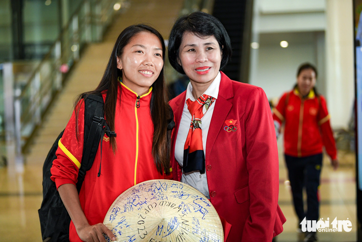 Phó cục trưởng Cục Thể dục thể thao Lê Thị Hoàng Yến (phải) chụp ảnh cùng Huỳnh Như tại sân bay Nội Bài - Ảnh: NAM TRẦN