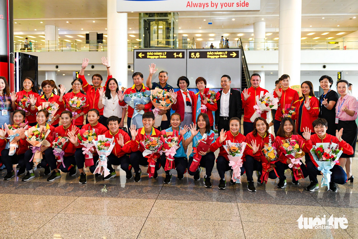 Đội tuyển nữ Việt Nam chụp ảnh lưu niệm tại sân bay Nội Bài - Ảnh: NAM TRẦN