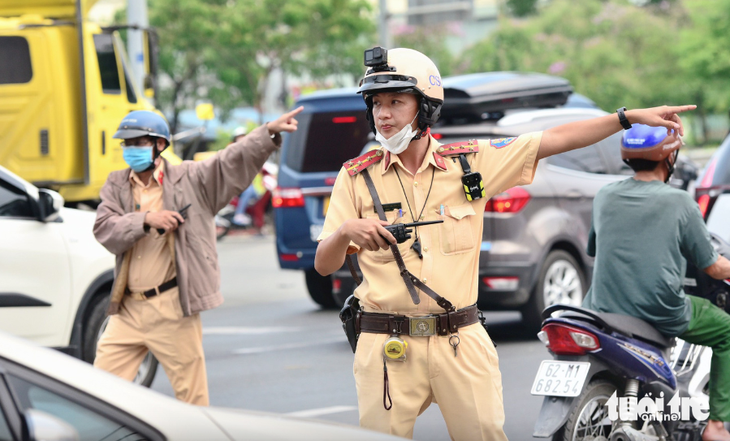 Lực lượng cảnh sát giao thông Đội An Lạc hướng dẫn người dân vào các đường nhánh, hẻm để giảm tải cho tuyến quốc lộ 1 vào dịp lễ 30-4 vừa qua - Ảnh: DUYÊN PHAN
