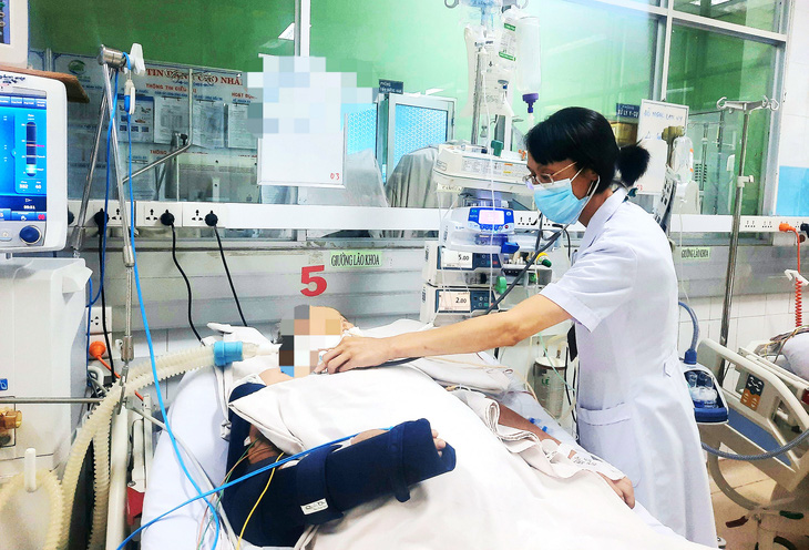 Bác sĩ thăm khám cho em N.H.N. (18 tuổi, Long An) sau 4 tuần điều trị tại Bệnh viện Bệnh nhiệt đới TP.HCM - Ảnh: THU HIẾN