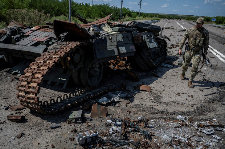 Quân nhân Ukraine đi gần một chiếc xe tăng Ukraine bị phá hủy gần làng Robotyne, vùng Zaporizhzhia, vào hôm 25-8 khi cuộc tấn công của Nga vào Ukraine vẫn tiếp diễn - Ảnh: REUTERS