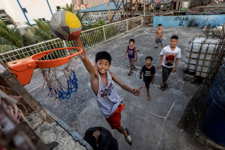 Bóng rổ là môn thể thao rất phổ biến tại Philippines, giống như đấm bốc. Nó được chơi ở bất cứ đâu và dường như ai cũng biết chơi. Trong hình, các em trai ở khu ổ chuột tại Tondo, Manila đang chơi trên sân bóng rổ được thiết kế ngay trên mái nhà - Ảnh: REUTERS