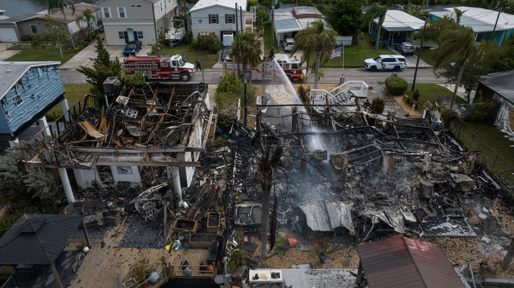 Lính cứu hỏa dập tắt đám cháy âm ỉ sau cơn bão Idalia ở Hudson, Florida, Mỹ, ngày 30-8 - Ảnh: REUTERS