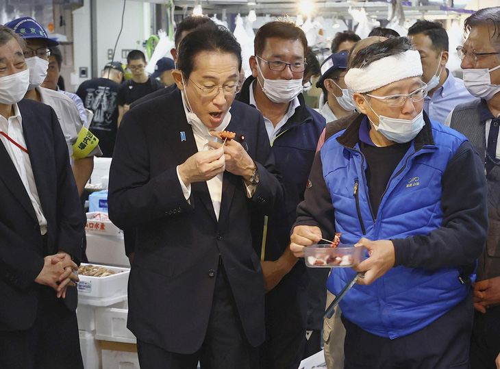 Thủ tướng Nhật Bản Kishida Fumio nếm thử hải sản từ vùng Fukushima trong chuyến thăm chợ cá Toyosu ở Tokyo ngày 31-8 - Ảnh: REUTERS
