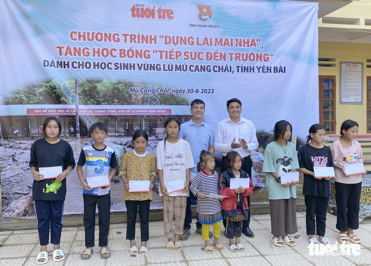 Đại diện báo Tuổi Trẻ và huyện đoàn Mù Cang Chải trao học bổng cho các em học sinh - Ảnh: NGỌC QUANG