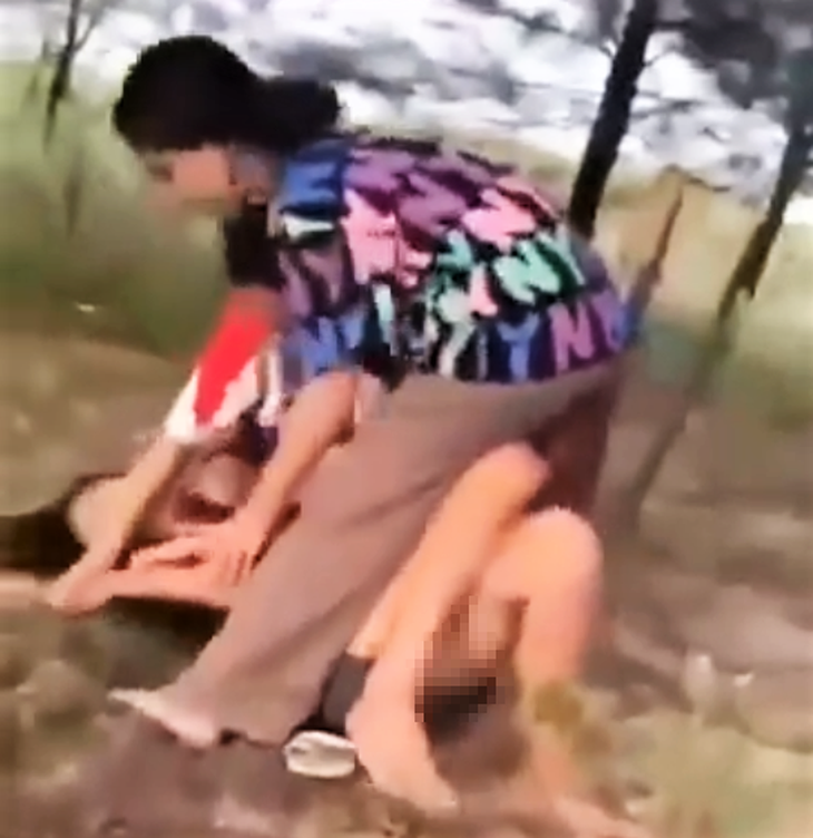 Hình ảnh ghi lại cảnh nữ sinh lớp 8 bị hai nữ sinh lớp 7 ghì xuống đất để lột quần gây phẫn nộ - Ảnh: Cắt từ clip