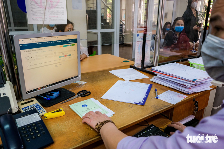 Cán bộ xử lý hồ sơ bảo hiểm xã hội của người lao động tại Hà Nội - Ảnh: NAM TRẦN