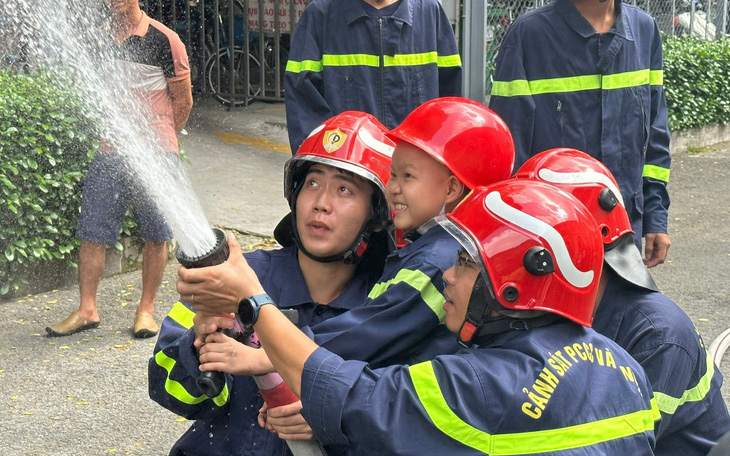 Cậu bé mắc ung thư cười khoái chí được làm "lính cứu hỏa"