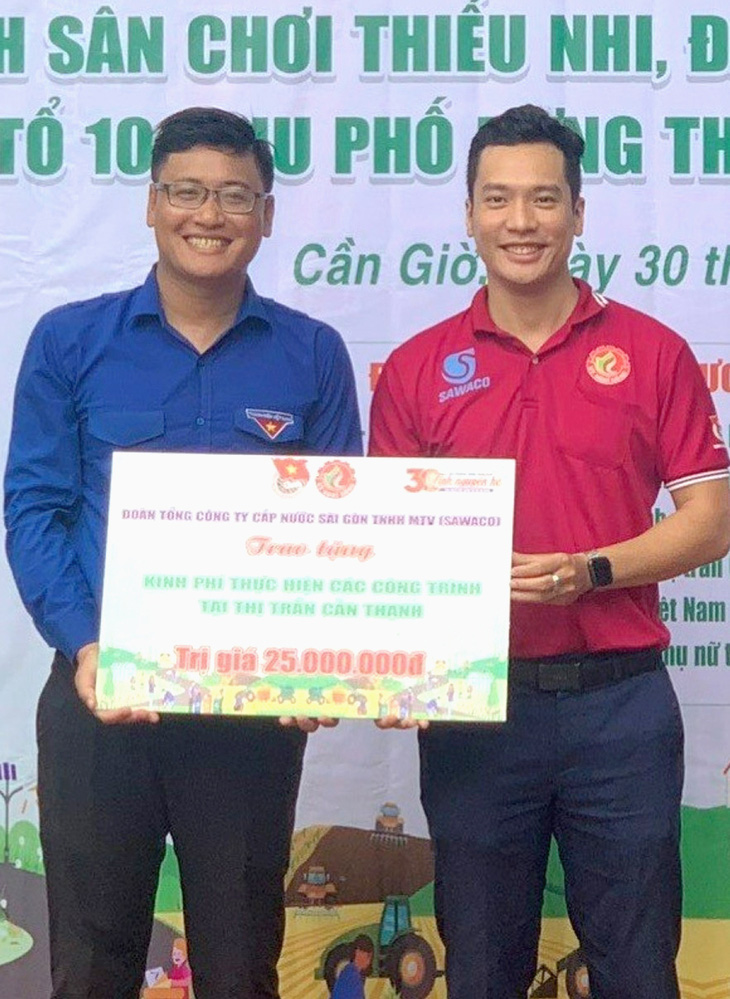Trịnh Tấn Phát (phải) đại diện đơn vị trao nguồn lực hỗ trợ thực hiện công trình tại huyện Cần Giờ (TP.HCM) - Ảnh: K.ANH