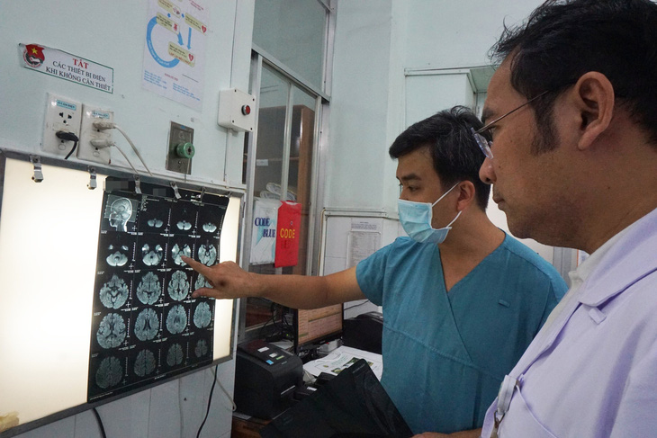 BS.CKII Đỗ Châu Việt (phải) và bác sĩ CKI Võ Thành Luân xem hình ảnh chụp MRI của bệnh nhi mắc tay chân miệng độ 4 - Ảnh: Bệnh viện cung cấp