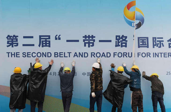 Các công nhân Trung Quốc di chuyển một tấm biển quảng bá hội nghị cấp cao BRI lần 2 tại Bắc Kinh năm 2019 - Ảnh: AFP 