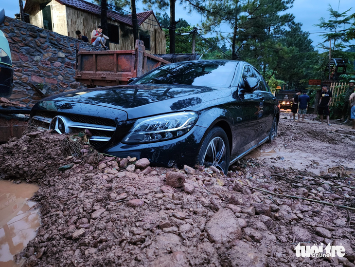 Một ô tô hạng sang bị đất đá vùi lấp ở khu vực hồ Ban Tiện, Sóc Sơn ngày 5-8 - Ảnh: QUANG VIỄN