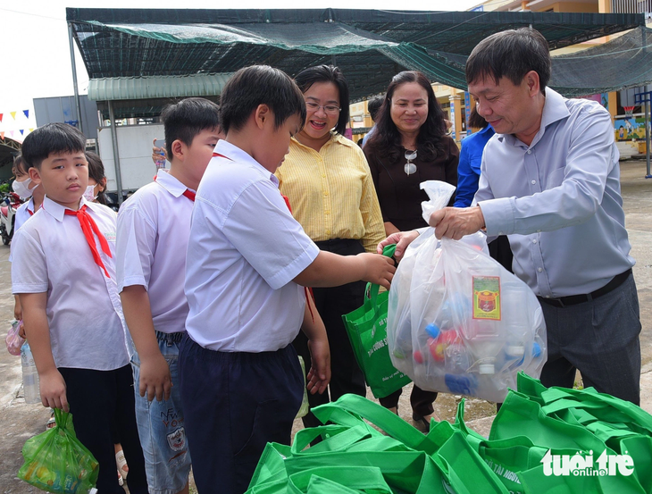 Ông Phan Văn Thắng - phó bí thư Tỉnh ủy Đồng Tháp - tặng quà cho học sinh, phát động thu gom rác thải nhựa - Ảnh: ĐẶNG TUYẾT