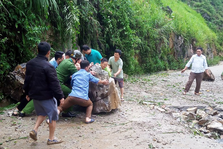 Lực lượng công an cùng người dân dọn dẹp hiện trường sạt lở đá ở Hòa Bình - Ảnh: Công an cung cấp