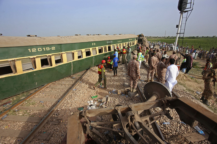 Các quan chức cảnh sát kiểm tra các toa tại địa điểm xảy ra vụ tàu hỏa trật đường ray ở Nawabshah ngày 6-8 - Ảnh: AFP