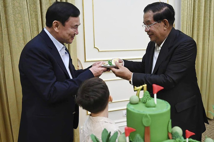 Thủ tướng Campuchia Hun Sen (phải) tặng quà lưu niệm cho cựu thủ tướng Thái Lan Thaksin Shinawatra tại Phnom Penh ngày 6-8 - Ảnh: AP