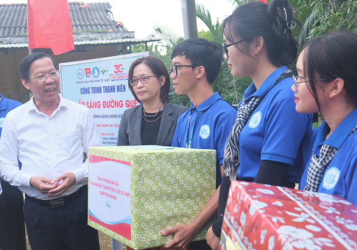 Chủ tịch UBND TP.HCM Phan Văn Mãi (bìa trái) tặng quà, trò chuyện cùng chiến sĩ tình nguyện Mùa hè xanh TP.HCM tại công trình các bạn mới bàn giao cho bà con ở Bến Tre năm 2023 - Ảnh: Q.LINH