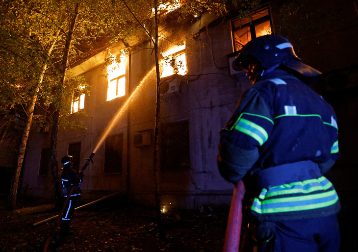 Lính cứu hỏa làm việc tại một tòa nhà trong giao tranh giữa Ukraine và Nga ở Donetsk ngày 5-8 - Ảnh: REUTERS 
