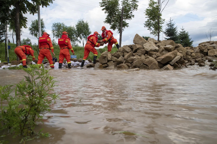 Lực lượng cứu hộ Trung Quốc đắp đá để ngăn dòng lũ tại tỉnh Hắc Long Giang hôm 5-8 - Ảnh: AP/Tân Hoa Xã