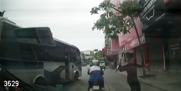 Hình ảnh xe khách của nhà xe Quang Mười bị chặn đường và có nhóm người cầm hung khí truy đuổi, hành hung tài xế ngay trên đường phố - Ảnh cắt từ video