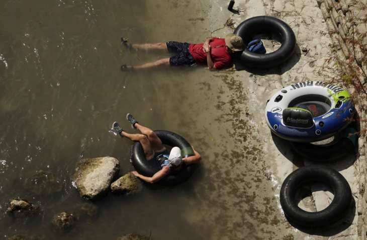 Một cặp đôi đang "giải nhiệt" tại một bờ sông bang Texas, Mỹ - Ảnh: AP